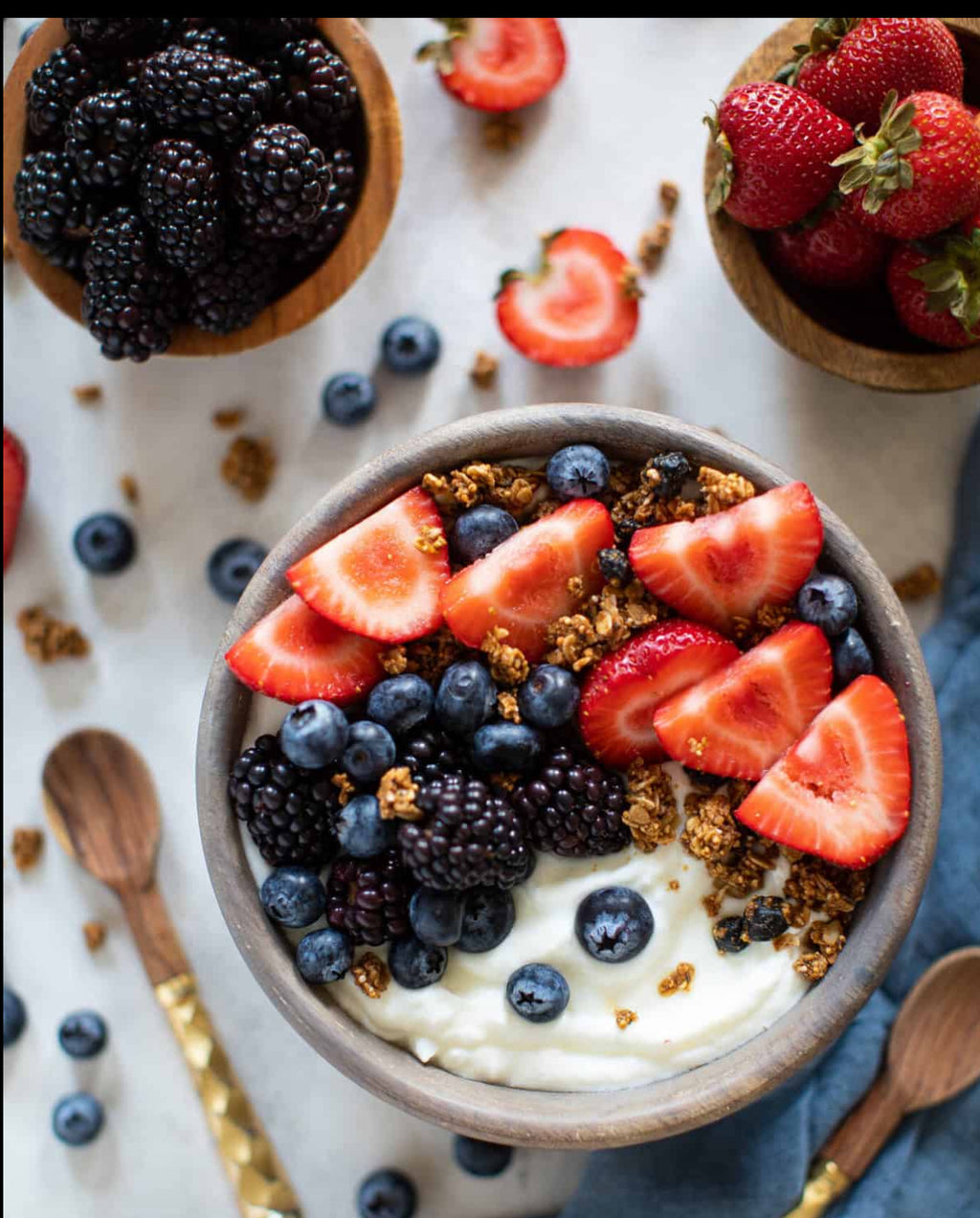 Yogurt bowl with granola, strawberries, blueberries and agave