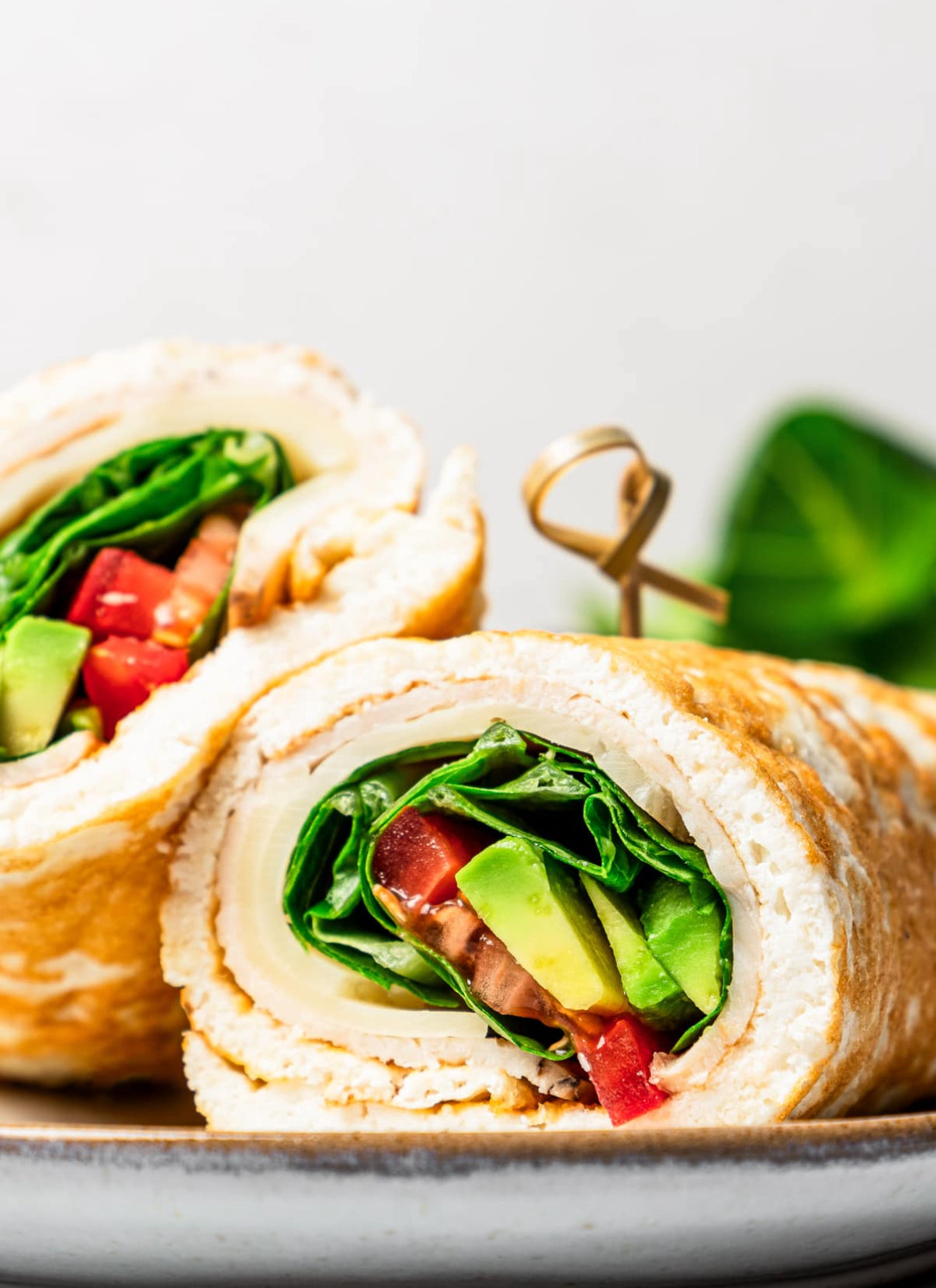 Close-up of a vegetable wrap with lettuce, tomato, and avocado turkey 